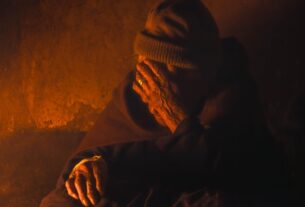 A senior monk in contemplation, enveloped in warm light, creating a serene atmosphere.