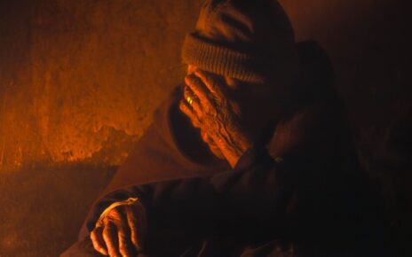 A senior monk in contemplation, enveloped in warm light, creating a serene atmosphere.