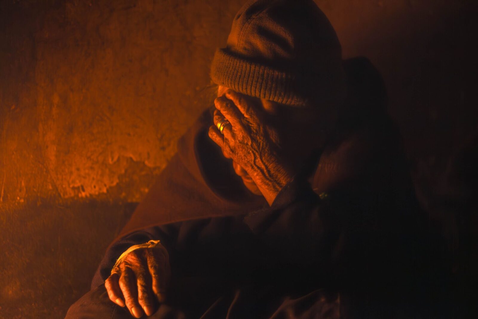 A senior monk in contemplation, enveloped in warm light, creating a serene atmosphere.